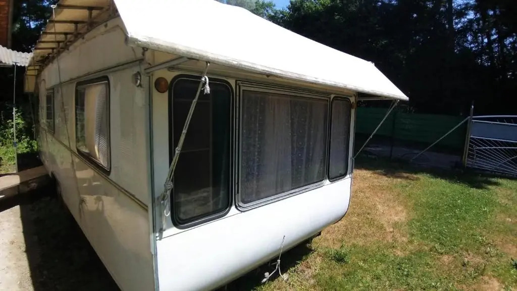 Geräumiger Wohnwagen unter Bäumen neben Mur-Stausee
