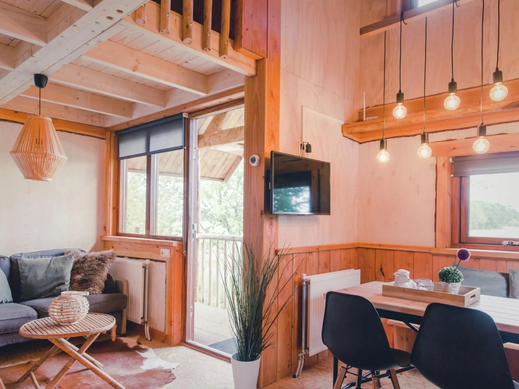 Beautiful wooden tree house with terrace in a holiday park on the river De Regge