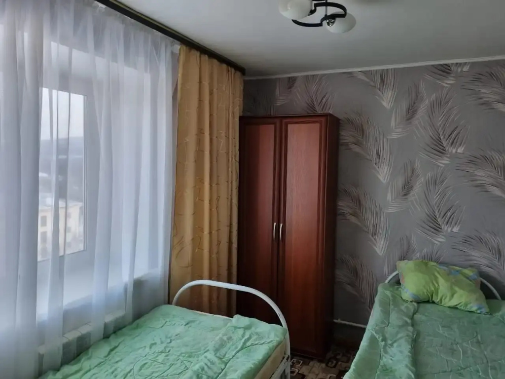 Кровать в общем номере с балконом и с видом на горы в Квартирное бюро