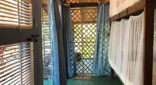 Кровать в общем номере Bhakti Kutir