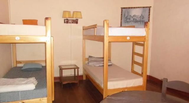 Кровать в общем номере Three Palms Fianar