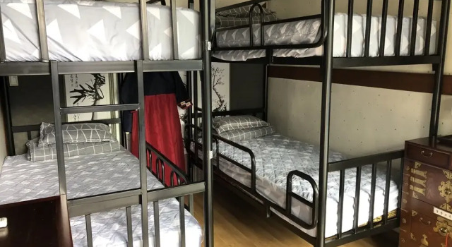 Cama en dormitorio compartido con vista The Hanok & Spa