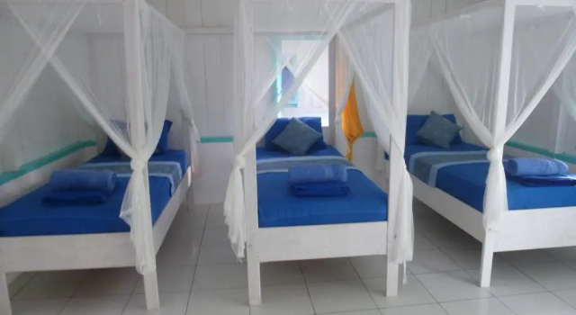 Кровать в общем номере Scuba Republic Beach Bungalows