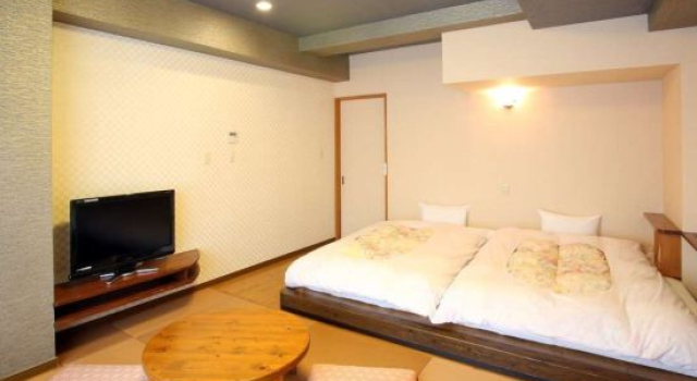 Кровать в общем номере Aso Uchinomaki Onsen Yumeoiso