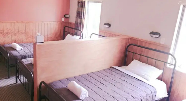 Кровать в общем номере Waitomo Village Chalets home of Kiwipaka