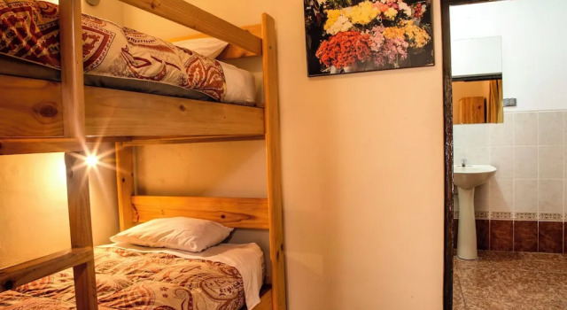 Postel ve společném pokoji a výhledem do dvora Bear Packer- Cusco