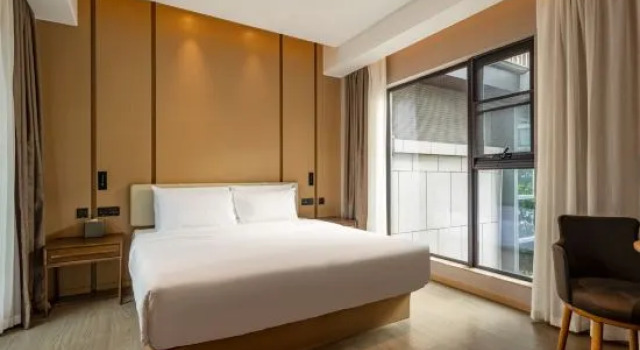 Łóżko w pokoju wieloosobowym Lujiang Mega Hotel