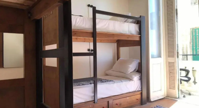 Postel ve společném pokoji pro muže Ithaka Hostel