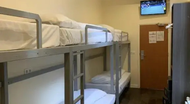Кровать в общем номере Dam Hotel