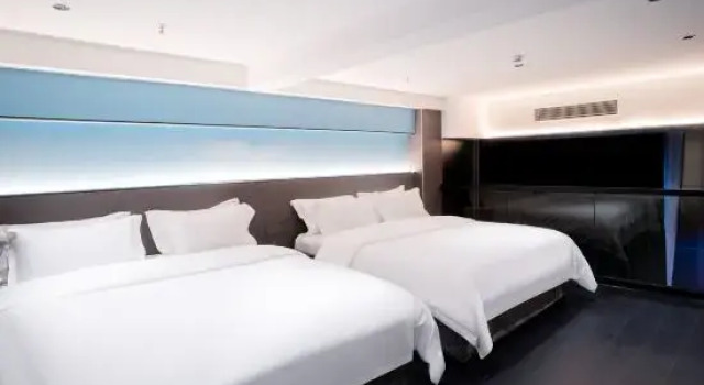 Łóżko w pokoju wieloosobowym Broad Joy Hotel