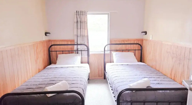 Кровать в общем номере Waitomo Village Chalets home of Kiwipaka