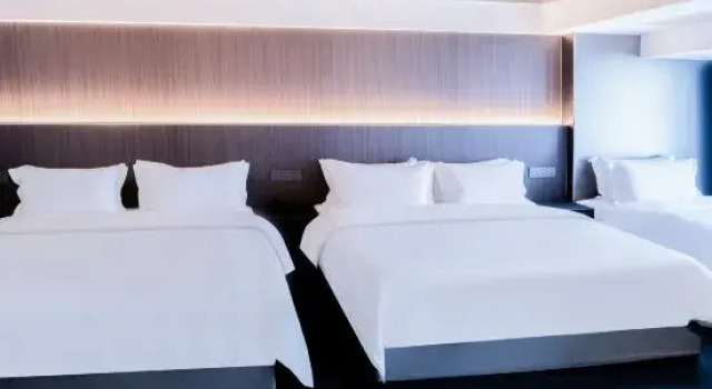 Łóżko w pokoju wieloosobowym Broad Joy Hotel