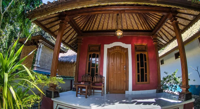 Кровать в общем номере с красивым видом из окна Nusa Garden Bungalow