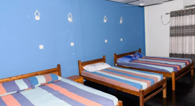 Кровать в общем номере Gnanam Holiday Inn