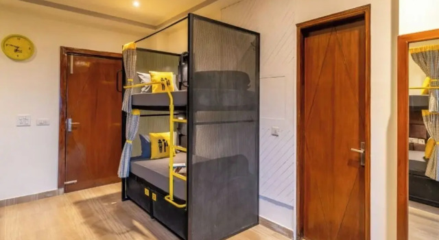 Кровать в общем номере с балконом и с красивым видом из окна The Hosteller Kasauli