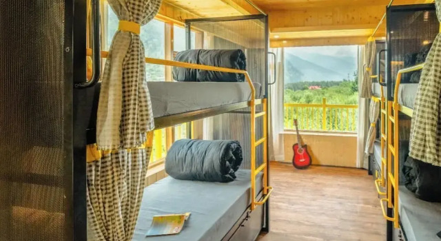 Кровать в общем номере с балконом и с красивым видом из окна The Hosteller Old Manali, Manu Temple