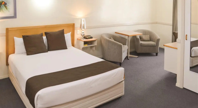 Кровать в общем номере Ambassador Motor Lodge