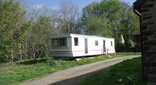 caravan nestled away amongst trees on edge of farm yard, จอง พักในฟาร์ม Llandderfel กวินเนดด์