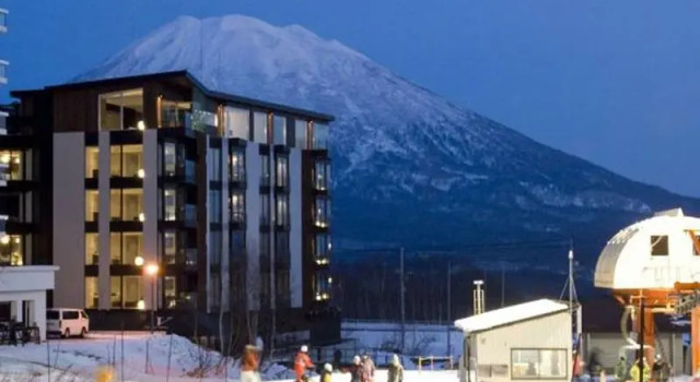Кровать в общем номере с красивым видом из окна The Vale Niseko