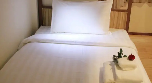 Łóżko w pokoju wieloosobowym Hotel Royal Rose