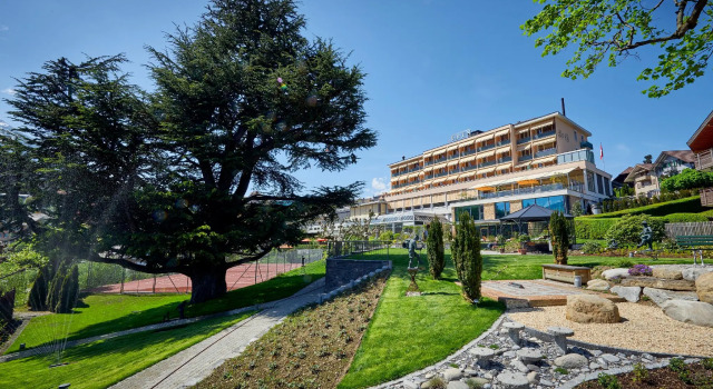 Кровать в общем номере с видом на озеро Ferienwohnungen Hotel Eden Spiez