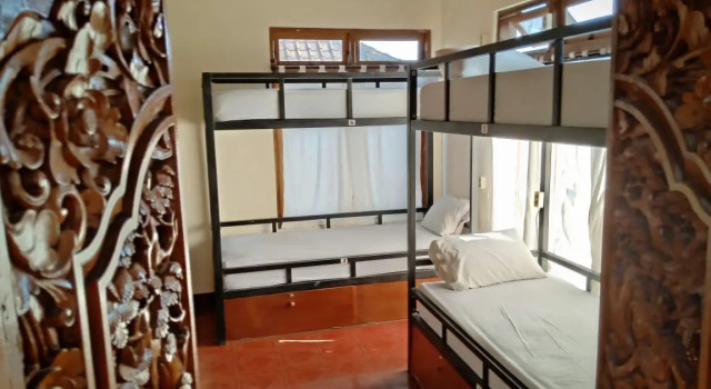 Кровать в общем номере Uma Kutuh Bungalow