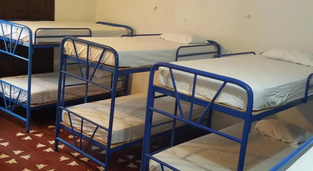 Кровать в общем номере Hostal El Jardin
