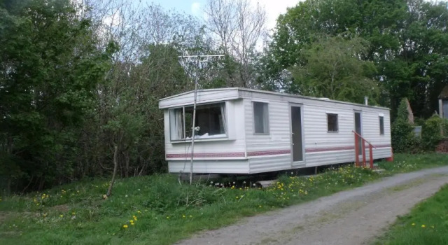 caravan nestled away amongst trees on edge of farm yard, จอง พักในฟาร์ม Llandderfel กวินเนดด์