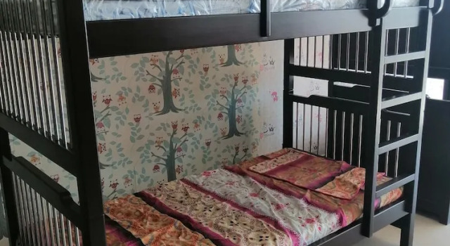 Łóżko w pokoju wieloosobowym i balkonem Maidi Backpacker