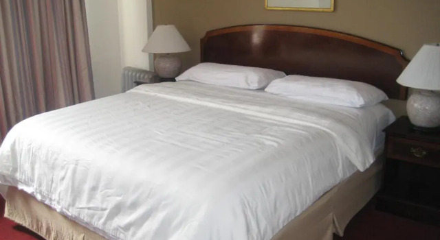 Кровать в общем номере Nash Hotel