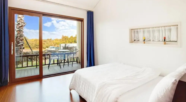 Кровать в общем номере Jeju Kiaora Resort