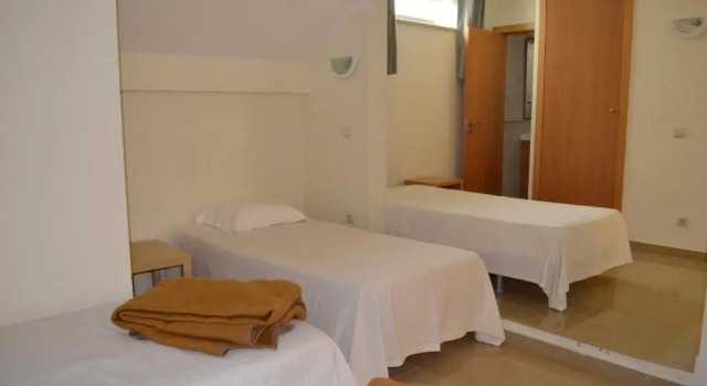 Кровать в общем номере Arenilha Guest House