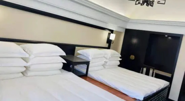 Кровать в общем номере Yilu Hotel
