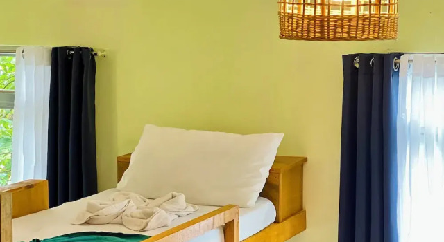 Кровать в общем номере Garden of Eden Dive Resort