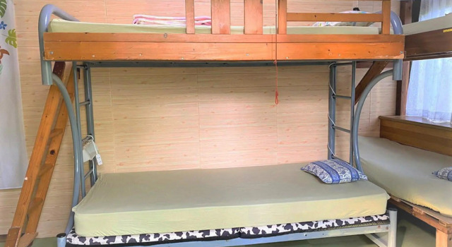 Кровать в общем номере Shiraho Friends House