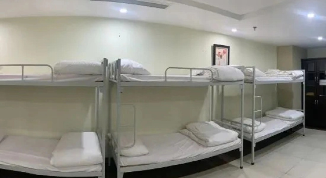 Кровать в общем номере New Century Hotel