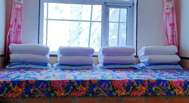Кровать в общем номере Xuegu Backpacker Inn (Snow Town Scenic Area)