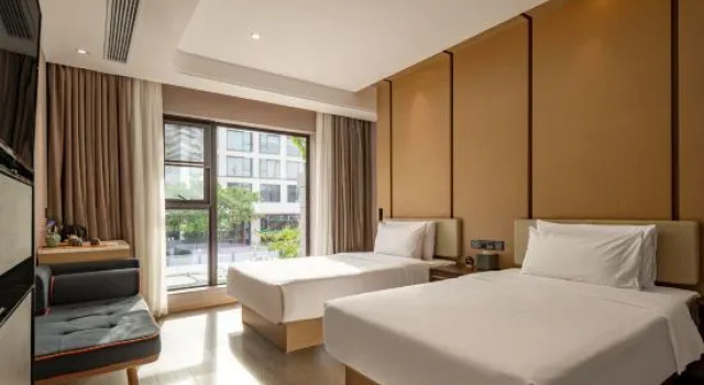 Łóżko w pokoju wieloosobowym Lujiang Mega Hotel