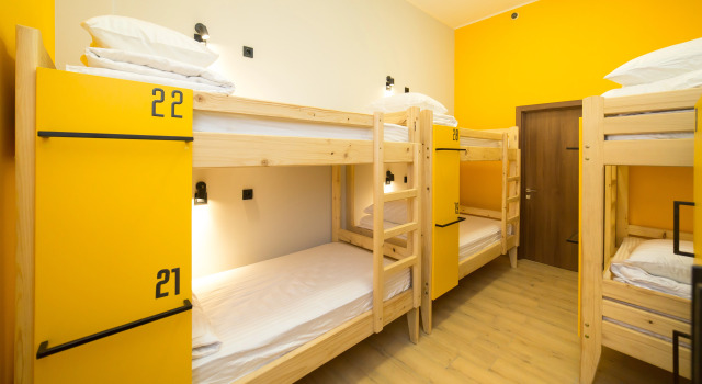 Кровать в общем номере с балконом и с красивым видом из окна HOTEL Bee Station